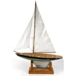 A pond yacht with full sail, green painted hull, on display stand, length 73cm.