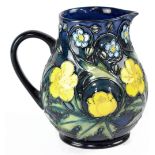 MOORCROFT; a midnight blue drip glaze ground jug with tube lined 'Primrose' pattern,