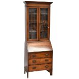 An early 20th century oak bureau bookcase with pair of leaded glazed doors enclosing three