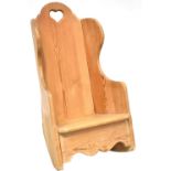 A rustic pine child's/doll's wing back rocking chair with heart-shaped motif to the back,