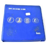 A blue album containing various world coinage.