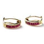 A pair of modern 14ct gold ruby earrings channel set with sixteen baguette rubies, lever backs,