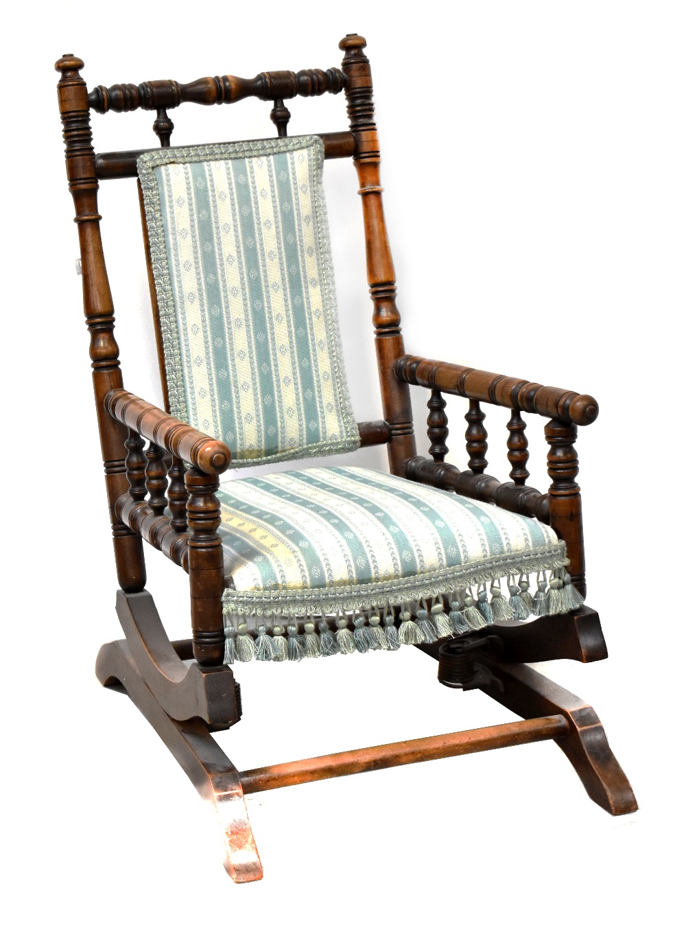 A late Victorian child's American rocking chair with turned supports and upholstered in a striped