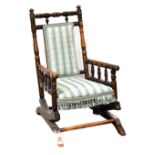 A late Victorian child's American rocking chair with turned supports and upholstered in a striped