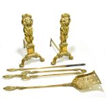 A brass Rococo style three piece companion set, together with a pair of brass fire dogs,