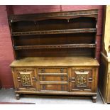 A reproduction oak sideboard, the plate rack back with two fixed shelves above the base section with