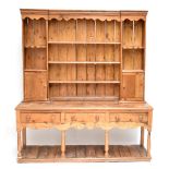 A rustic pine country kitchen dresser, the raised back with an arrangement of five shelves and two