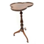 An mid-20th century wine table, the tri-form top raised on baluster supports terminating on splay