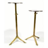 A pair of early 20th century Arts and Crafts style brass adjustable stands, with circular top raised