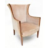 An Edwardian line inlaid mahogany framed wing back chair, upholstered in a beige material.