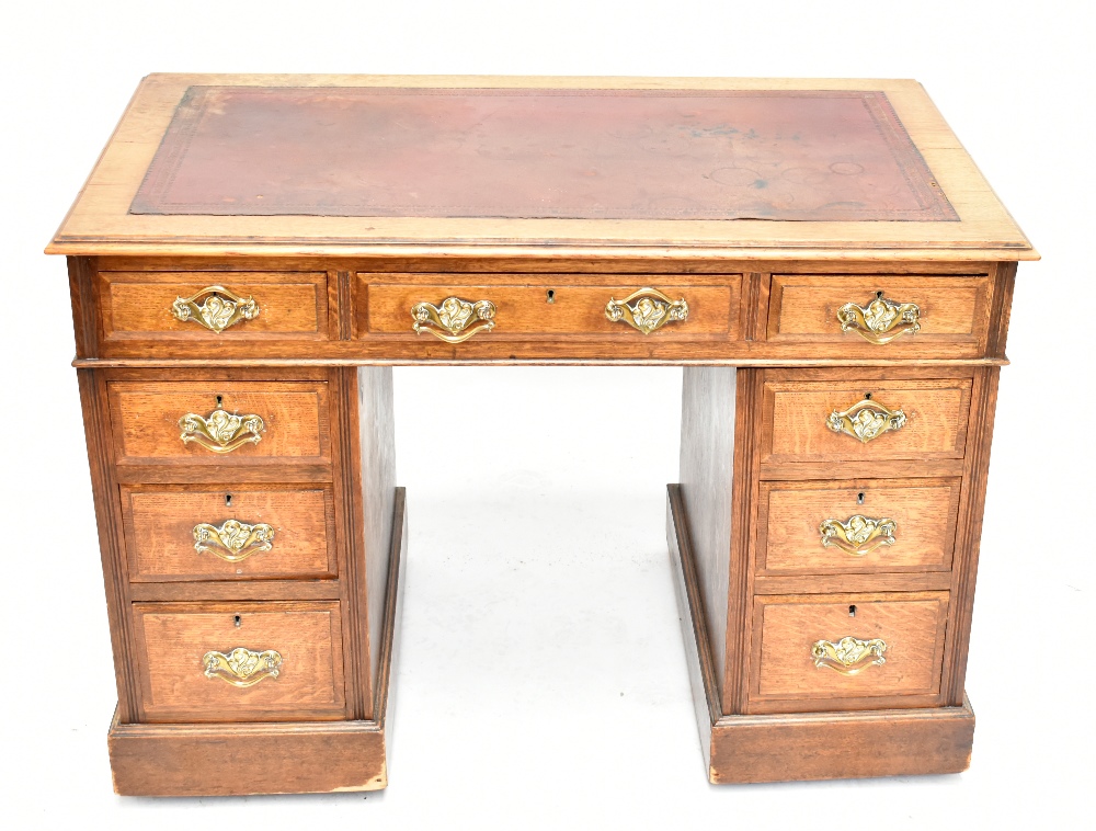 An oak twin pedestal writing desk with arrangement of two short and one long drawer above two