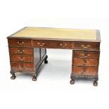 A mahogany pedestal desk, with green leather inset top above an arrangement of nine drawers, on ball