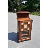 A late Victorian carved walnut music cabinet with carved galleried back, the single door with