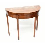 A Georgian mahogany demi-lune foldover card table raised on tapering block supports, width 91cm,