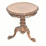 A 19th century walnut occasional table with carved edge and undertier section, raised on carved