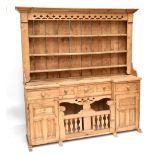 A Victorian-style pine country kitchen dresser, with pierced frieze above three open shelves over an