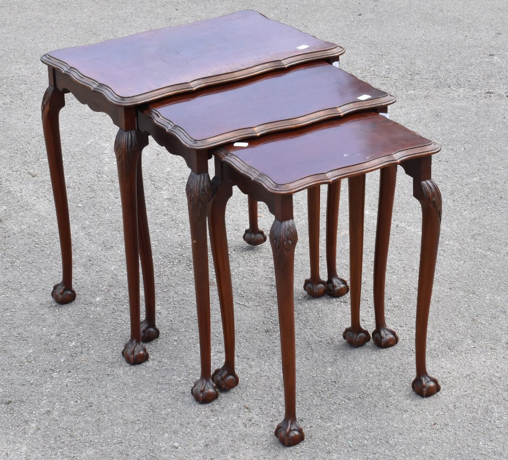 A 1950s mahogany nest of three graduated coffee tables, raised on turned column supports terminating