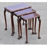 A 1950s mahogany nest of three graduated coffee tables, raised on turned column supports terminating