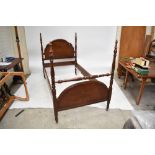 A modern inlaid mahogany single bedstead, with arched head and foot boards, raised on turned