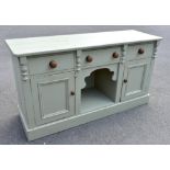 A pale green painted pine country kitchen dresser base, with three drawers and two panelled cupboard