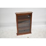 An early 20th century mahogany glazed wall cabinet with single door enclosing three shelves,