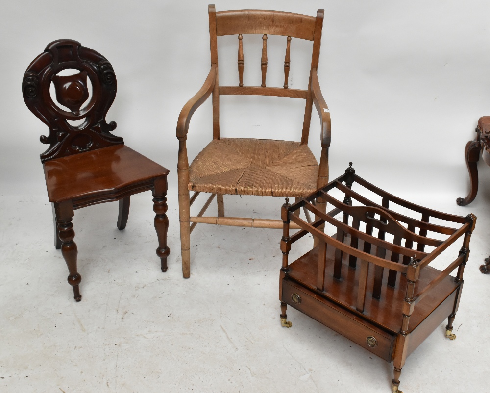 A mid-Victorian mahogany hall chair with carved back on turned front supports, a rush seated