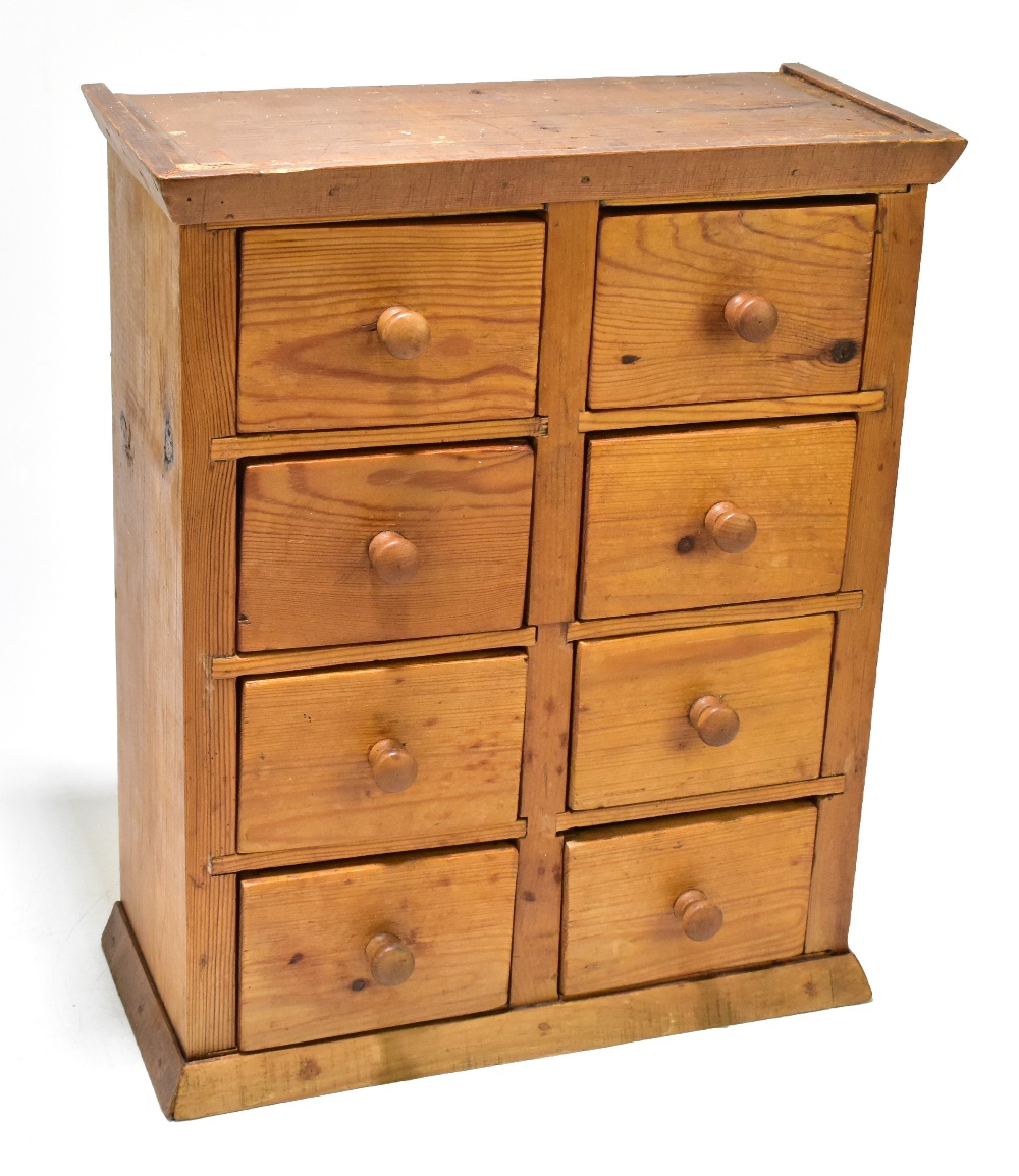 A pine miniature chest of eight drawers, raised on plinth base, width 33.5cm, height 40.5cm, depth