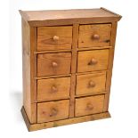 A pine miniature chest of eight drawers, raised on plinth base, width 33.5cm, height 40.5cm, depth