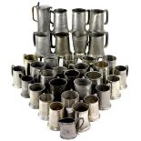 A large quantity of pewter tankards to include English pewter hammered examples,