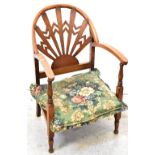 An early 20th century Arts & Crafts style low chair, cut-out fretwork, sunburst back to curved arms,