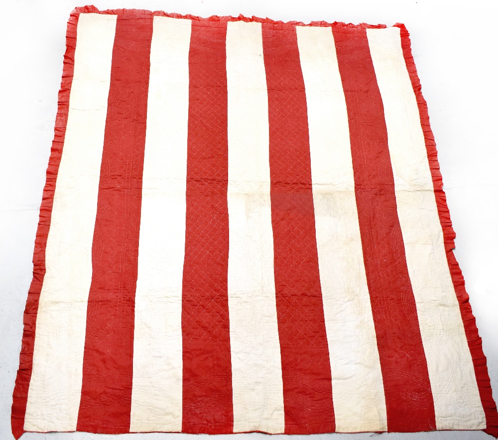 An early 20th century Welsh/Durham quilt, each side with ivory and deep red stripes, 218 x 187cm.