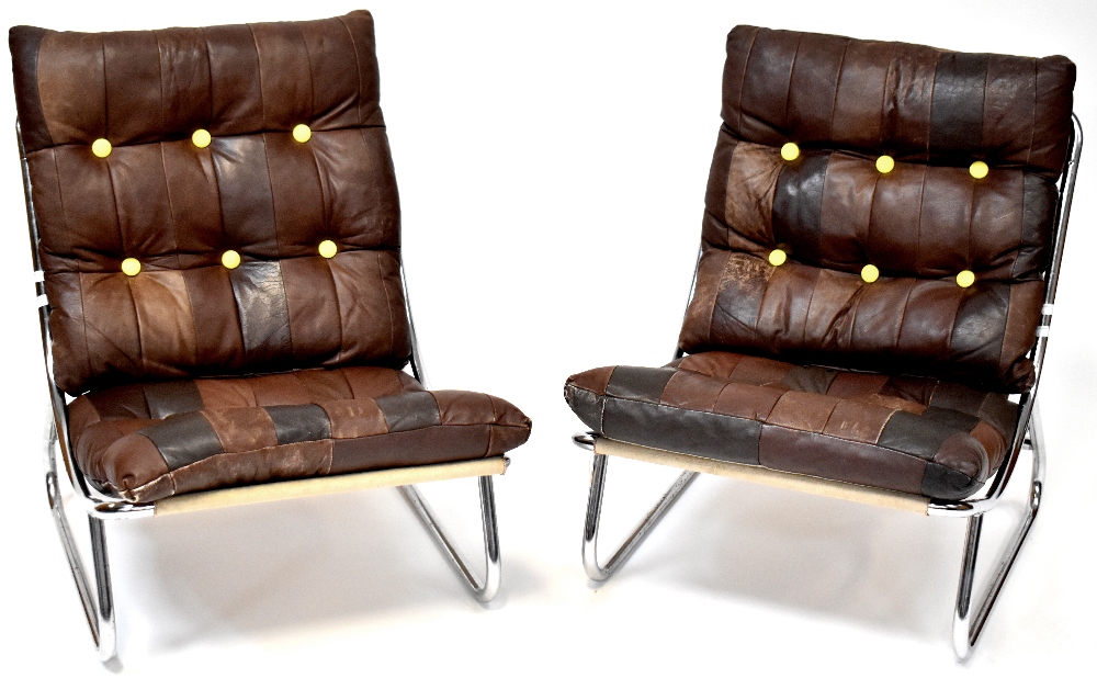 A pair of mid-20th century retro low lounge chairs with button pressed brown leather pads over a