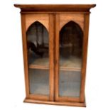 A small tabletop pine bookcase with pair of arched glazed doors raised on plinth base,