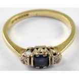 An 18ct gold diamond and blue stone ring a central blue stone flanked by two illusion set tint