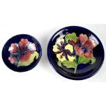 WALTER MOORCROFT; two 'Hibiscus' pattern items comprising a pedestal footed bowl with blue ground,