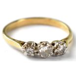 A yellow metal diamond ring with three claw set brilliant cut diamonds,