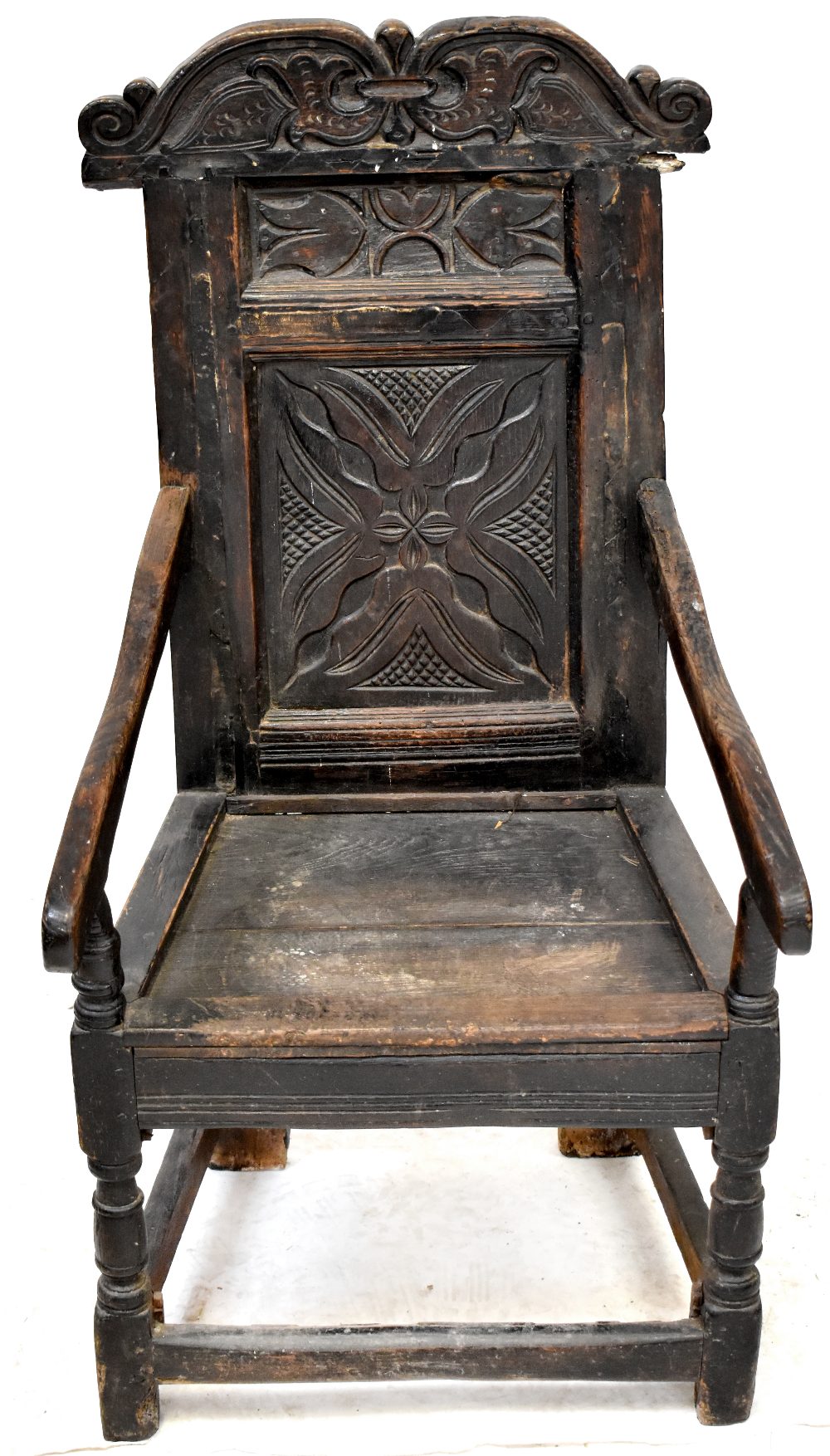 A 17th century carved oak wainscot armchair,