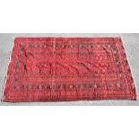 A 20th century Middle Eastern Bokhara-type rug with typical detail on red ground, approx 254 x