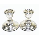 A pair of George V hallmarked silver squat candlesticks on loaded circular bases, Chester 1920,