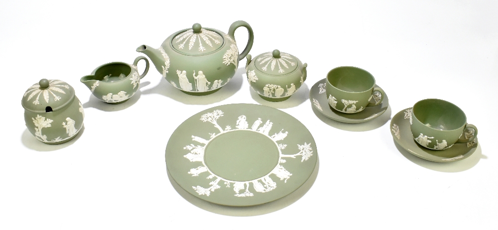 WEDGWOOD; a green jasperware three-piece tea set, together with a pair of tea cups and saucers, a