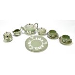 WEDGWOOD; a green jasperware three-piece tea set, together with a pair of tea cups and saucers, a