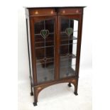 An Art Nouveau inlaid mahogany display cabinet, with pair of leaded glazed doors enclosing two fixed