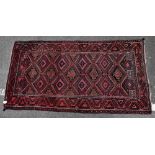 An Eastern style Bokhara type rug with geometric decoration on a red ground, 194 x 101cm.