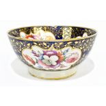 An early 19th century English hand painted porcelain bowl decorated throughout with reserves of