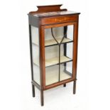 An Edwardian inlaid mahogany display cabinet, the single glazed door enclosing two fixed shelves,
