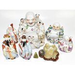 A collection of 20th century Chinese porcelain figures including Fu Lu Shou, three seated Buddhas