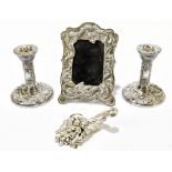 A pair of modern hallmarked silver candlesticks, profusely decorated throughout with scrolls, a