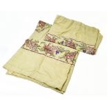 A pair of hand embroidered linen table cloths decorated throughout with floral designs in bright