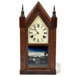 An American mahogany architectural eight day mantel clock, the door decorated with a reverse glass