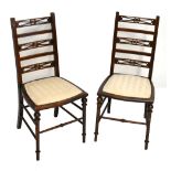 A pair of Edwardian mahogany ladder back bedroom chairs, raised on turned column supports.